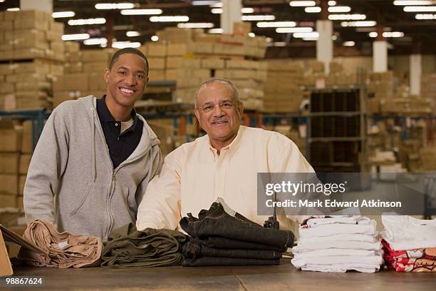 manager standing with worker in warehouse - mark atkinson stock pictures, royalty-free photos & images