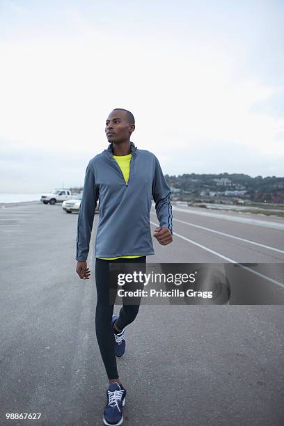 athletic black man walking along road - sportsman stock pictures, royalty-free photos & images