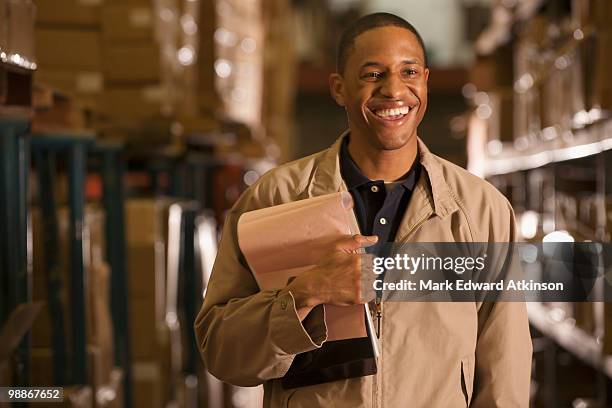 black man working in warehouse - mark atkinson stock pictures, royalty-free photos & images
