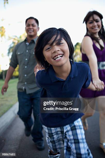 boy laughing and pulling mother and father - coronado island stock pictures, royalty-free photos & images
