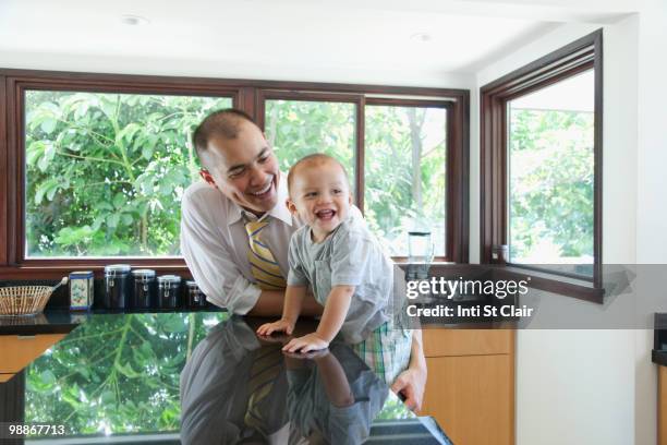 father and son in kitchen - inti st clair stock pictures, royalty-free photos & images