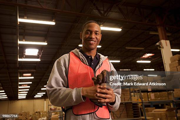 black man in reflector-vest in warehouse - luggage hold stock pictures, royalty-free photos & images