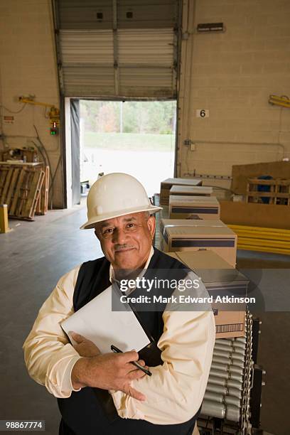 mixed race man in hard-hat in warehouse - luggage hold stock pictures, royalty-free photos & images