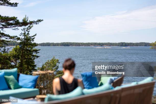 Guests sits on a terrace looking out to the Baltic sea on SuperShe island near Raasepori, Finland, on Wednesday, June 27, 2018. The price of...