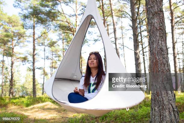 Guest mediates in a suspended pod chair on SuperShe island near Raasepori, Finland, on Wednesday, June 27, 2018. The price of experimental networking...