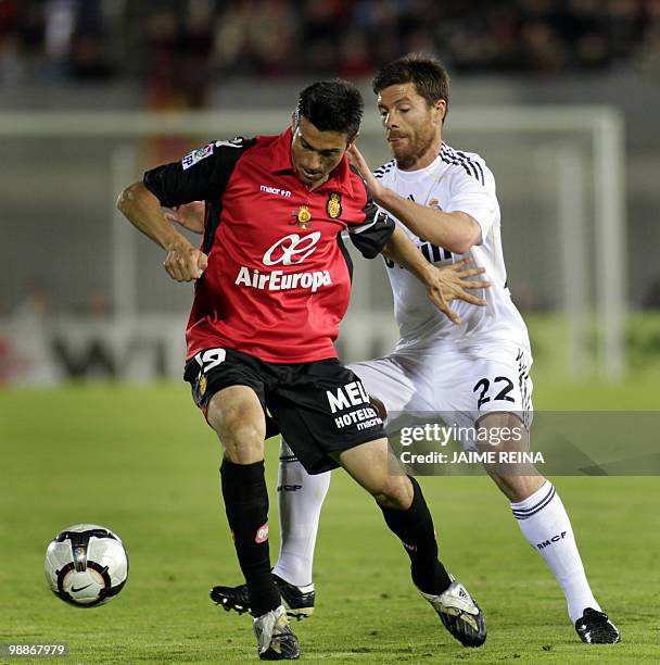 Mallorca's midfielder Jose Luis Marti vies with Real Madrid's midfielder Xabi Alonso during their Spanish League football match at the Ono Stadium in...