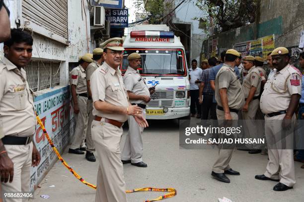 An ambulance enters the street where 11 family members were found dead inside their home in the neighbourhood of Burari in New Delhi on July 1, 2018....