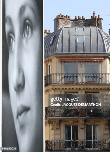 People stand on their balcony as they watch pall bearers carry the coffins of former French politician and Holocaust survivor Simone Veil and her...