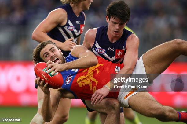 Rhys Mathieson of the Lions gets tackled by Andrew Brayshaw of the Dockers during the round 15 AFL match between the Fremantle Dockers and the...