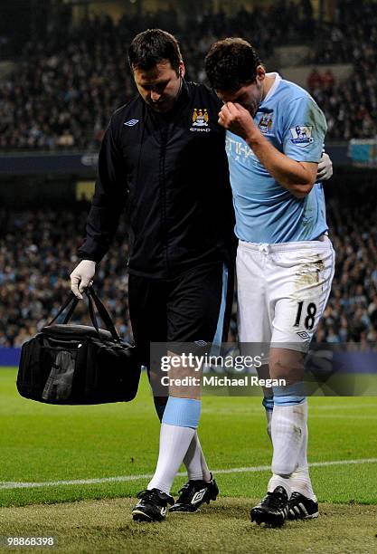 Gareth Barry of Manchester City is helped from the pitch with an injury during the Barclays Premier League match between Manchester City and...