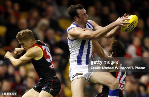 Todd Goldstein of the Kangaroos marks the ball over Matt Guelfi of the Bombers and Mark Baguley of the Bombers during the 2018 AFL round15 match...