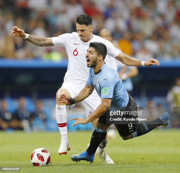 Luis Suarez of Uruguay falls after being marked by Jose Fonte of Portugal during the first half of Uruguay's 2-1 win in a World Cup round-of-16 match...