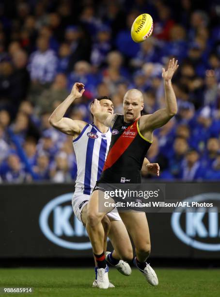 Jake Stringer of the Bombers and Scott Thompson of the Kangaroos compete for the ball during the 2018 AFL round15 match between the Essendon Bombers...