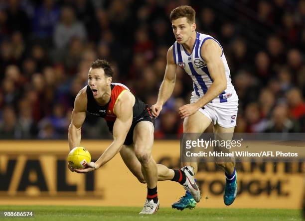 Matt Dea of the Bombers and Shaun Atley of the Kangaroos compete for the ball during the 2018 AFL round15 match between the Essendon Bombers and the...