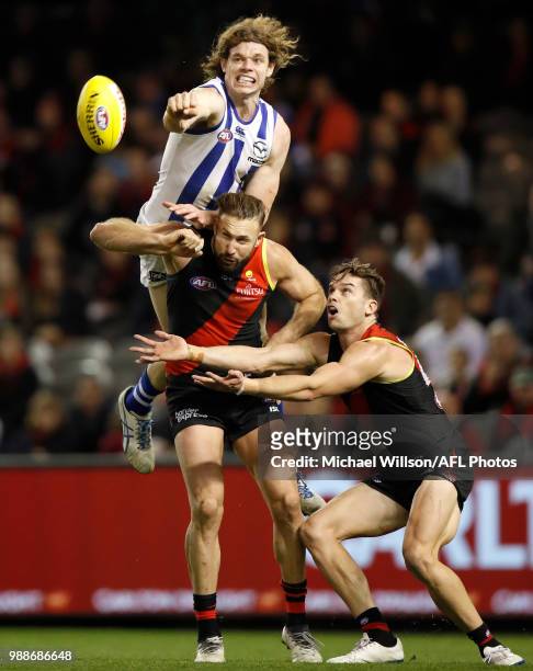 Ben Brown of the Kangaroos, Cale Hooker of the Bombers and Patrick Ambrose of the Bombers compete for the ball during the 2018 AFL round15 match...