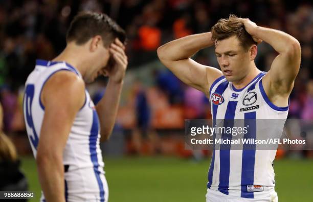 Sam Wright and Shaun Higgins of the Kangaroos look dejected after a loss during the 2018 AFL round15 match between the Essendon Bombers and the North...