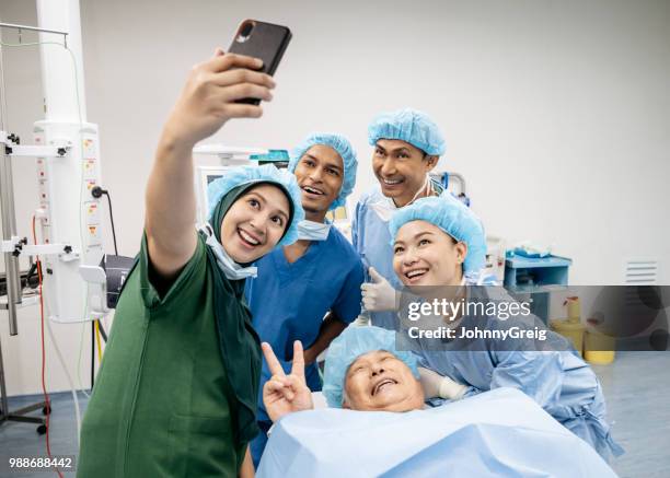 medisch team selfie met patiënt in operatiekamer - funny surgical masks stockfoto's en -beelden