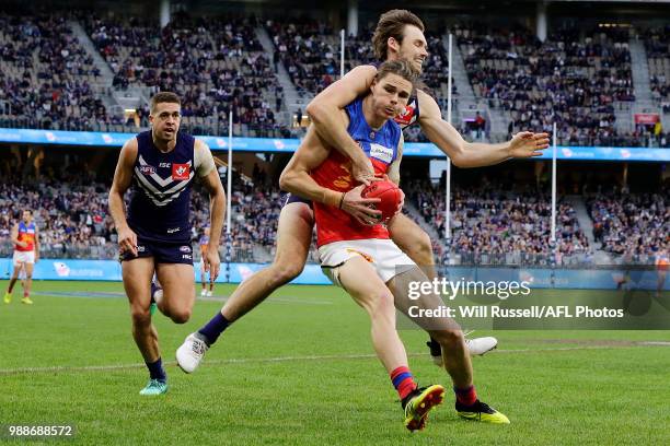 Stefan Martin of the Lions is tackled by Joel Hamling of the Dockers during the round 15 AFL match between the Fremantle Dockers and the Brisbane...