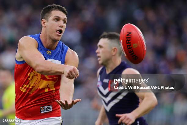 Jake Barrett of the Lions handpasses the ball during the round 15 AFL match between the Fremantle Dockers and the Brisbane Lions at Optus Stadium on...