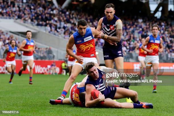 Luke Ryan of the Dockers is tackled by Dayne Beams of the Lions during the round 15 AFL match between the Fremantle Dockers and the Brisbane Lions at...