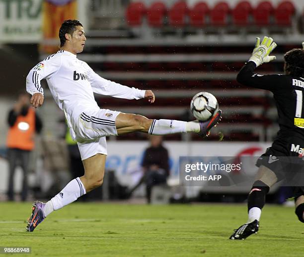 Real Madrid's Portuguese forward Cristiano Ronaldo shots to score against Mallorca's Israeli goalkeeper Dudu Aouate during their Spanish League...