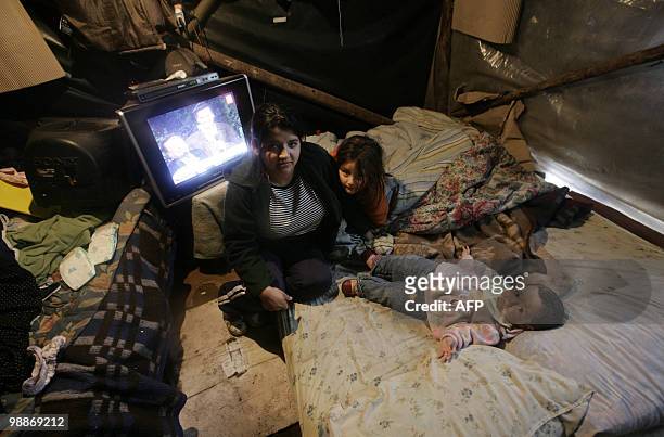Family stays inside their their emergency dwelling at Penco's port in Concepcion, some 500 km south of Santiago, May 5, 2010. The first autumn rains...