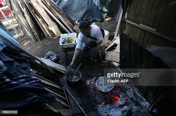 Woman cooks inside her tent at a provisional encampment for refugees of February 27th's earthquake and the ensueing tsunami at Penco's port in...