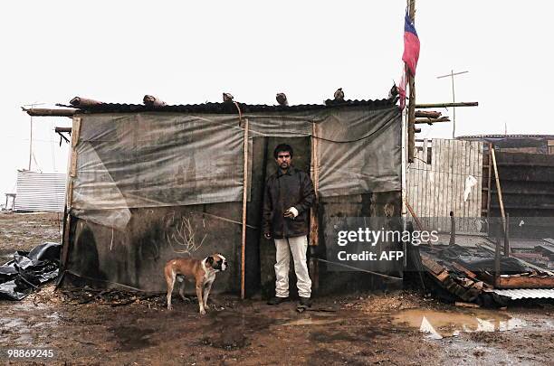 Stands in front of a shack he built at a provisional encampment for refugees of February 27th's earthquake and the ensueing tsunami at Penco's port...