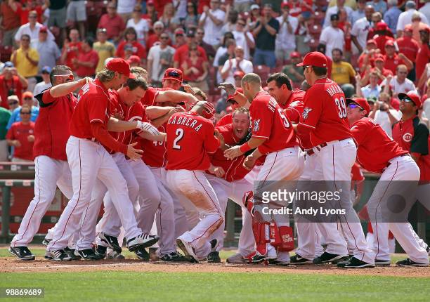 Orlando Cabrera of the Cincinnati Reds is surrounded by teammates after hitting the game winning home run in the 10th inning against the New York...