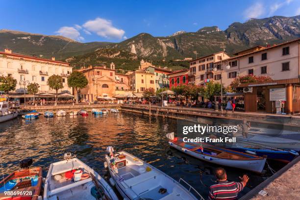 view of boats in malcesine harbour by the lake, malcesine, lake garda, veneto, italian lakes, italy, europe - malcesine stock pictures, royalty-free photos & images