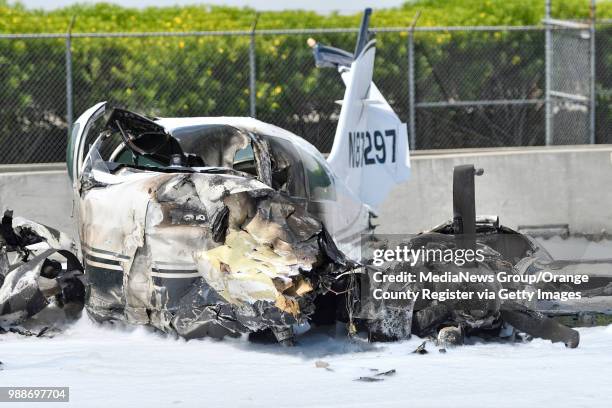 The burnt remains of a small plane sits on the southbound 405 freeway next to John Wayne Airport in Irvine, California, on Friday, June 30, 2017....
