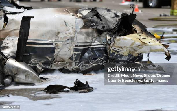 The burnt remains of a small plane sits on the southbound 405 freeway next to John Wayne Airport in Irvine, California, on Friday, June 30, 2017....