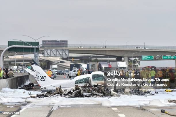 The burnt remains of a small plane sits on the southbound 405 freeway next to John Wayne Airport in Irvine, California, on Friday, June 30, 2017....