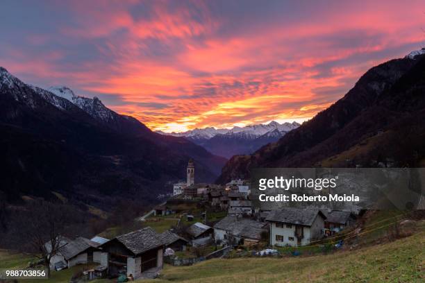 sunset over the alpine village of soglio, bregaglia valley, maloja region, canton of graubunden (grisons), switzerland, europe - região de maloja - fotografias e filmes do acervo