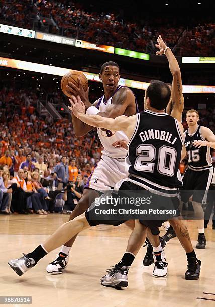 Channing Frye of the Phoenix Suns handles the ball under pressure from Manu Ginobili of the San Antonio Spurs during Game One of the Western...