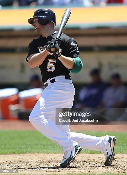 Kevin Kouzmanoff of the Oakland Athletics hits an RBI sacrafice in the first inning against the Texas Rangers during an MLB game at the...