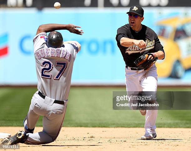 Vladimir Guerrero of the Texas Rangers slides into second as Cliff Pennington of the Oakland Athletics throws to first on a double play hit by Ian...