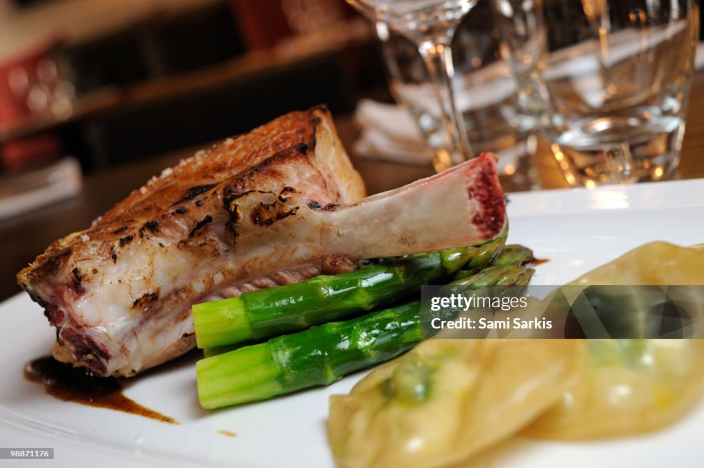 Grilled beef rib on asparagus with potatoes, dish