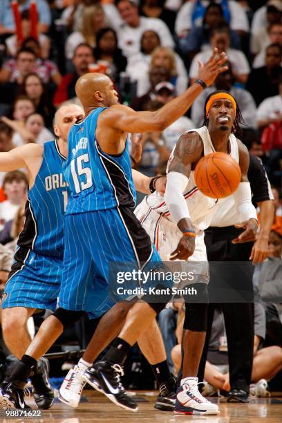 Gerald Wallace of the Charlotte Bobcats passes the ball around Vince Carter of the Orlando Magic in Game Four of the Eastern Conference Quarterfinals...