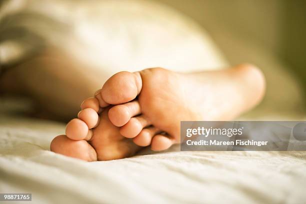 feet in bed - mareen fischinger stock pictures, royalty-free photos & images