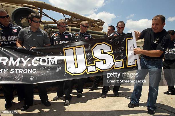 Ryan Newman, driver of the U.S. Army Chevrolet Impala, reveals a autographed banner during Ryan Newman and Stewart-Haas Racing at Fort Benning at on...