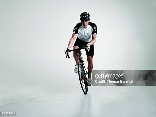 male cyclist standing in pedals riding bike - endurance cycling stock pictures, royalty-free photos & images