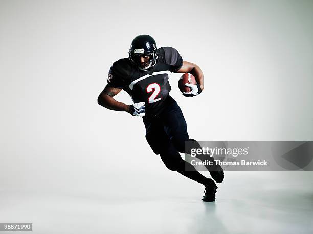 football player running with ball - football-spieler stock-fotos und bilder