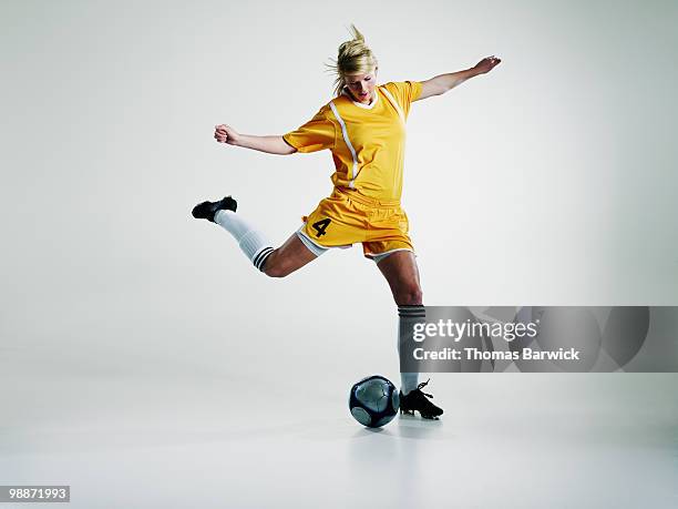 female soccer player preparing to kick soccer ball - fußballspieler stock-fotos und bilder