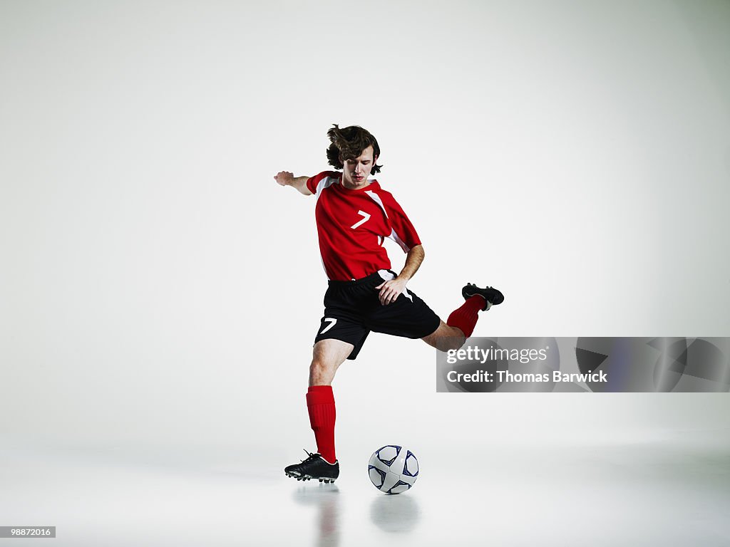 Male soccer player preparing to kick soccer ball
