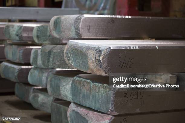 slabs of titanium alloy sit in a storage area - titânio imagens e fotografias de stock