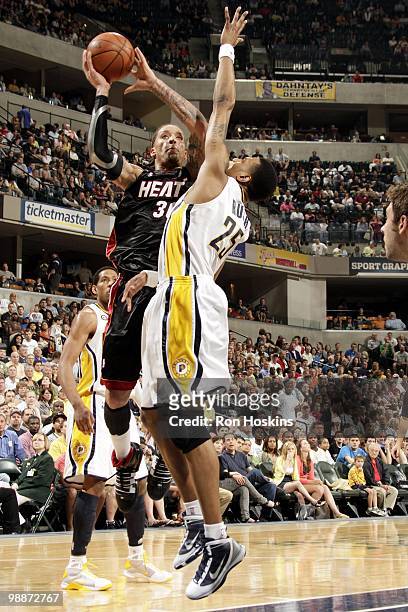Michael Beasley of the Miami Heat puts a shot up against Brandon Rush of the Indiana Pacers during the game at Conseco Fieldhouse on April 2, 2010 in...