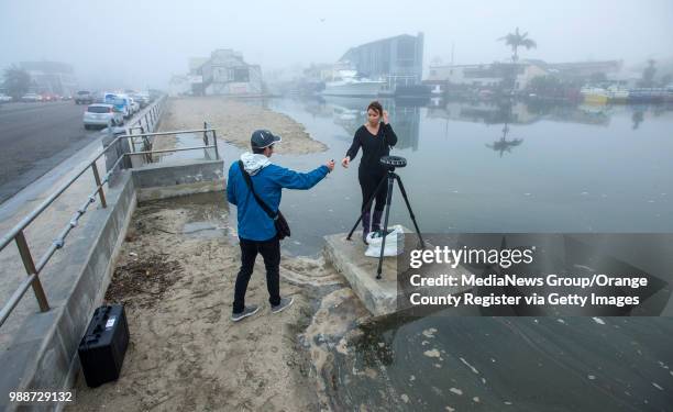 Nick Sadrpour, left, a science research and policy specialist for the Sea Grant Program at University of Southern California, hands a level to...
