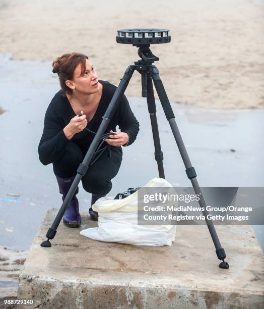 Juliette Finzi Hart with the U.S. Geological Survey, prepares to plug power into a 360 degree video camera made by Google to record a high tide in...