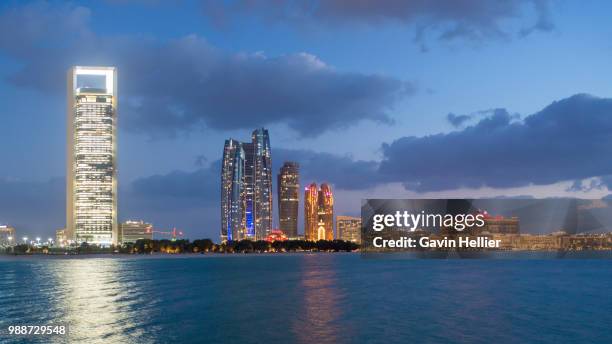 etihad towers and emirates palace hotel viewed from the breakwater, abu dhabi, united arab emirates, middle east - emirates towers stock pictures, royalty-free photos & images